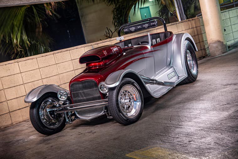 A red and silver car parked in the street.